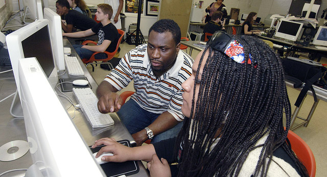 person helping student on the computer
