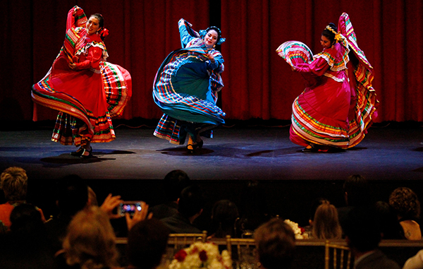 Ballet Folklorico dancers on stage in colorful dresses