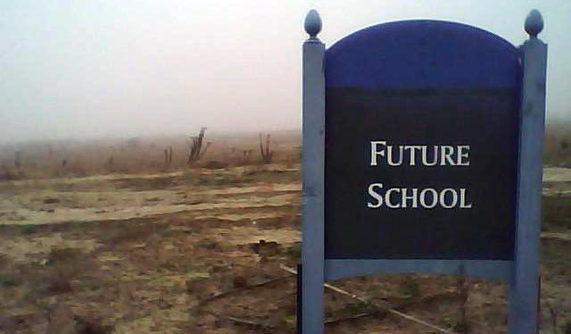 a sign that says future school before an empty lot