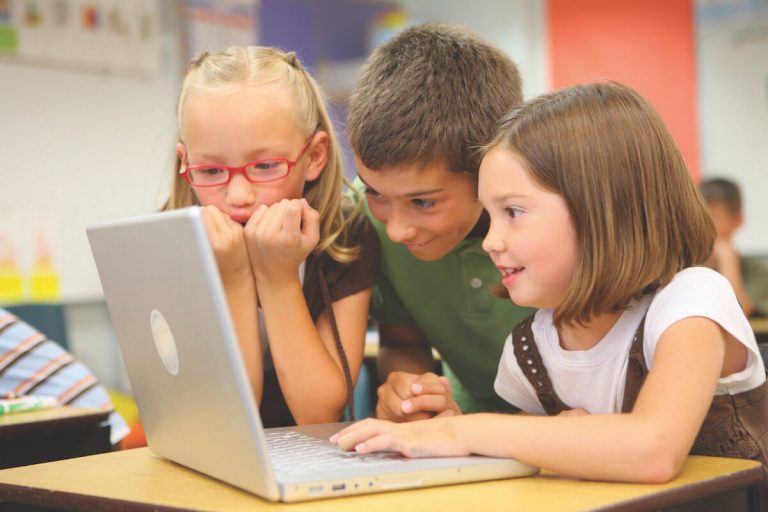 3 young kids playing on a laptop computer
