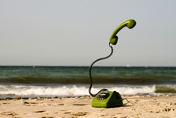 green phone in the sand at beach