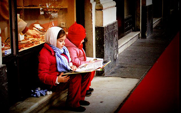 girls reading books on a bench