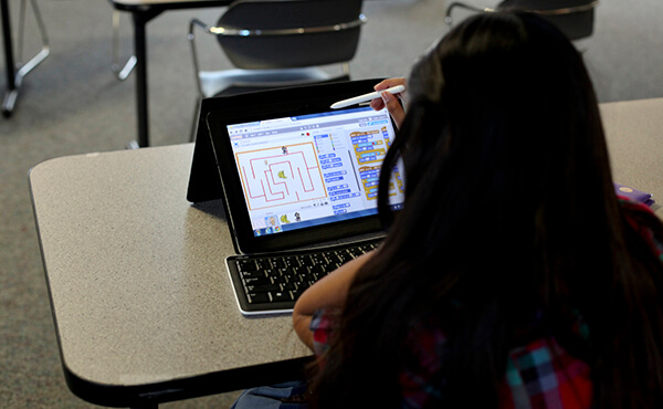 girl works on coding program on ipad