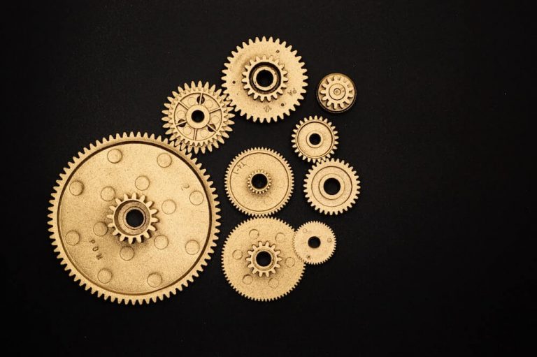 Gold gears of various sizes sit against a black background
