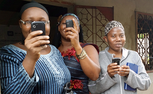 three women using cellphones to take pictures