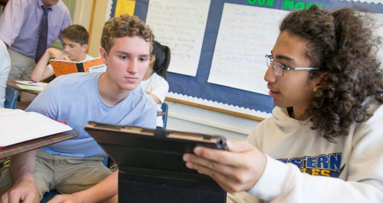 Two students looking at ipad in classroom