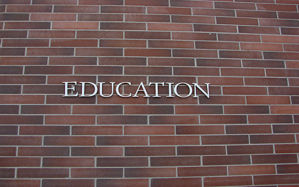 word education on brick building wall